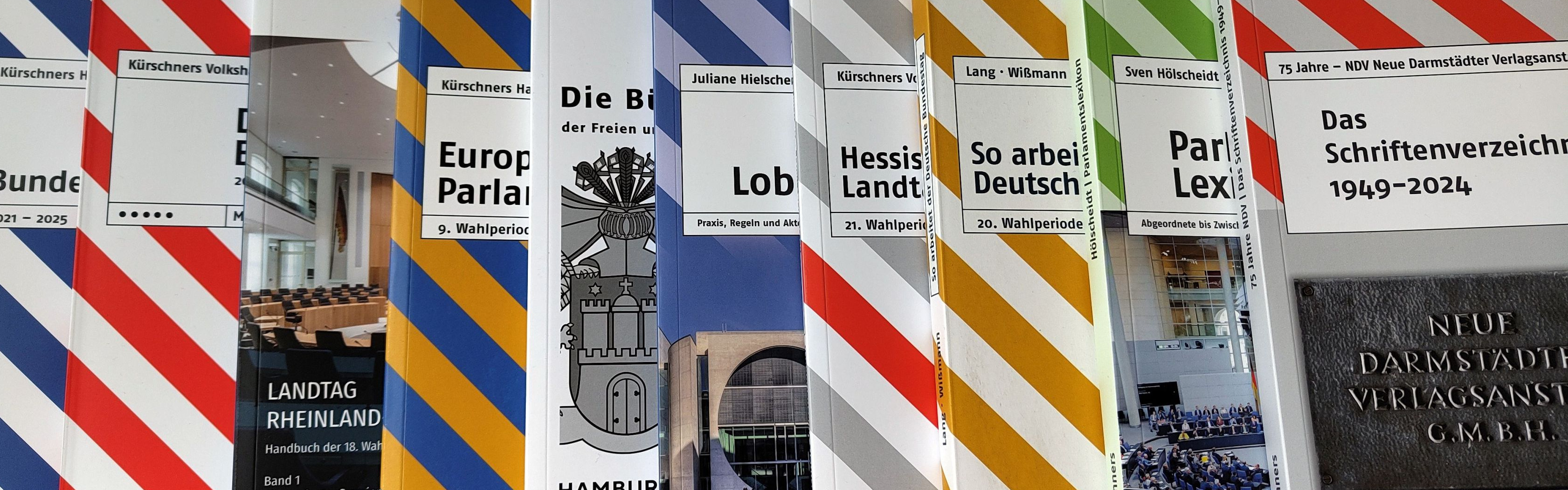 Mehrere bunt gestreifte Bücher aus dem Verlag NDV Kürschners Politikkontakte.
