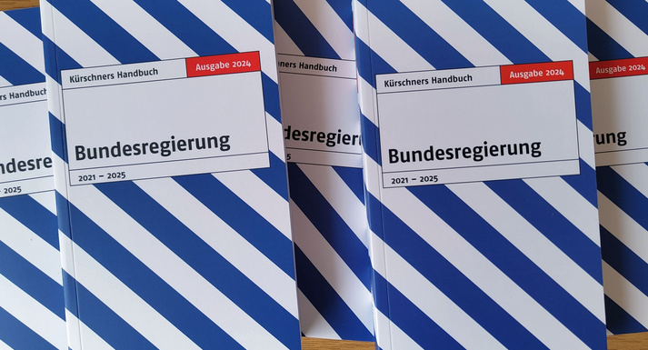 Nebeneinander liegende Exemplare des blau-weiß gestreiften Titels Kürschners Handbuch Bundesregierung.